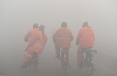 Afghan municipality workers ride bicycles through amid dense fog in Kabul on January 5, 2016. AFP PHOTO / SHAH Marai (Photo by SHAH MARAI / AFP)